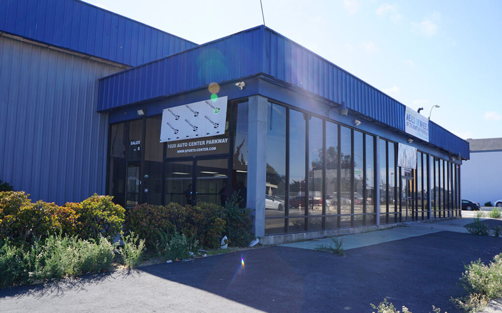 Exterior of the purchased building for the second Meals on Wheels of the Monterey Peninsula kitchen with a temporary Meals on Wheels sign.