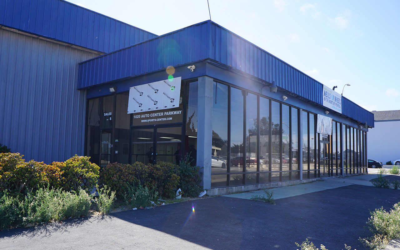 Exterior of the purchased building for the second Meals on Wheels of the Monterey Peninsula kitchen with a temporary Meals on Wheels sign.
