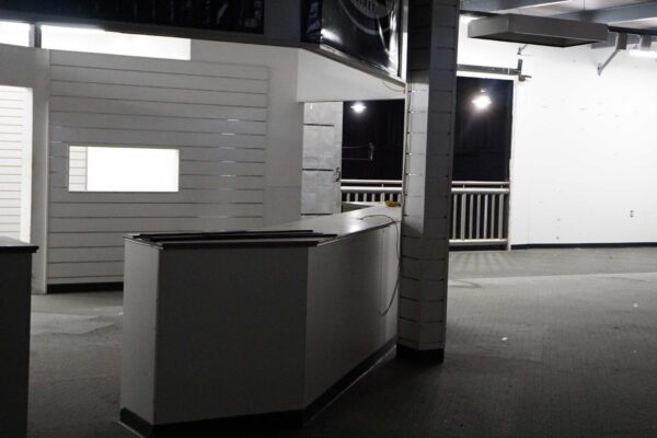 Interior of the purchased building for the second Meals on Wheels of the Monterey Peninsula kitchen with open space, old carpeting, and existing counter area.