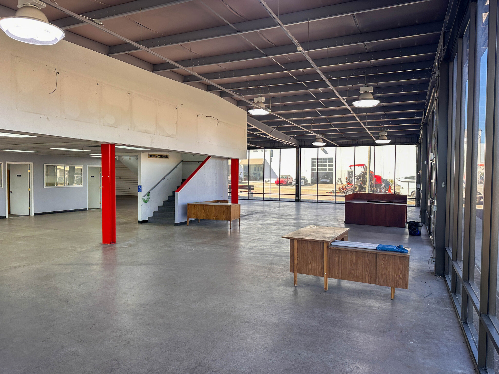 Original interior of the purchased building for the second Meals on Wheels of the Monterey Peninsula kitchen showing open concrete flooring, support columns, and large windows.
